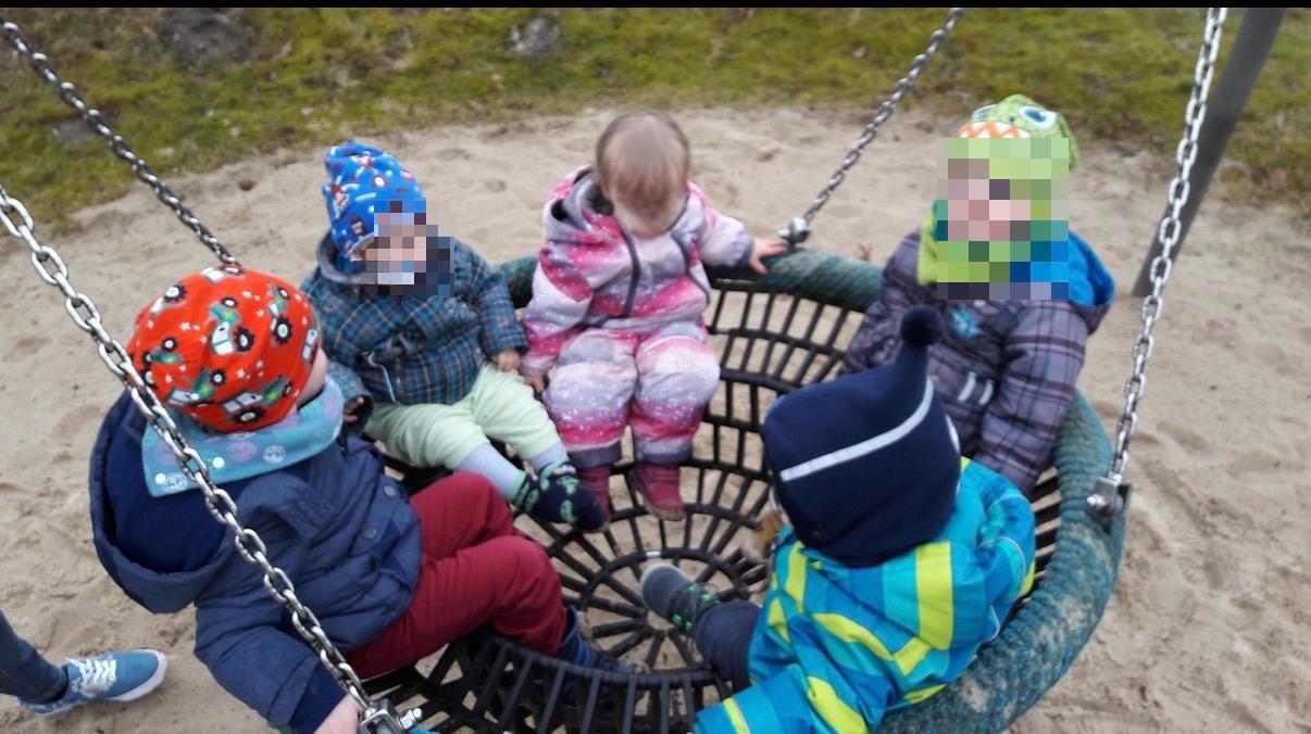 Kinder auf einer Nestschaukel
